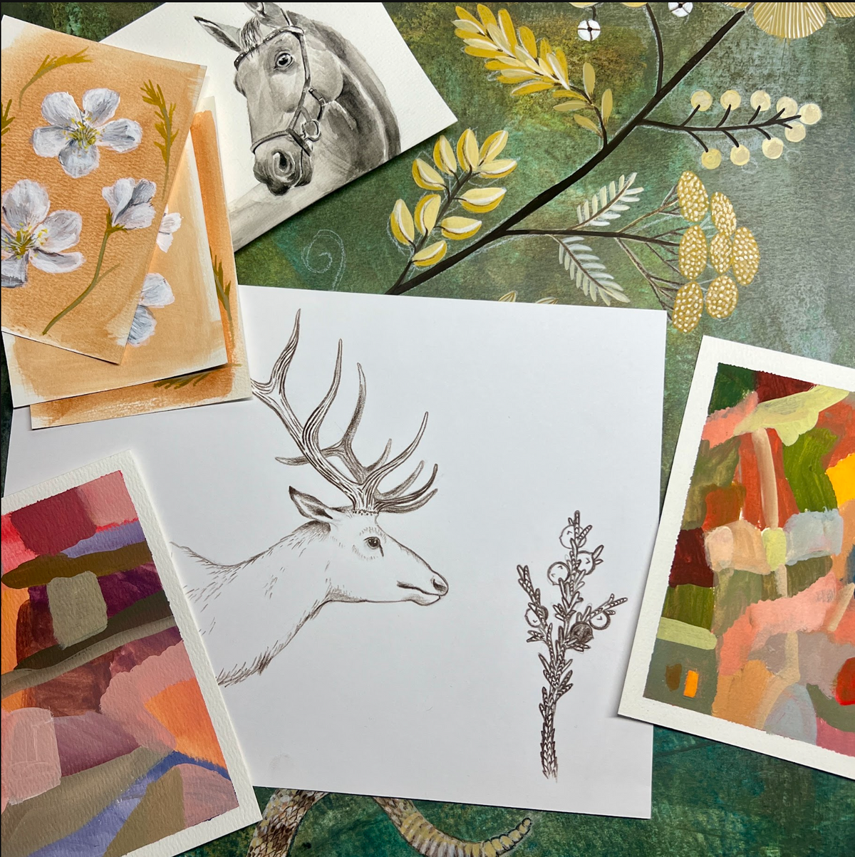 Studio table with elk, horse and flower paintings in progress at Matty Miller Studio in Denver