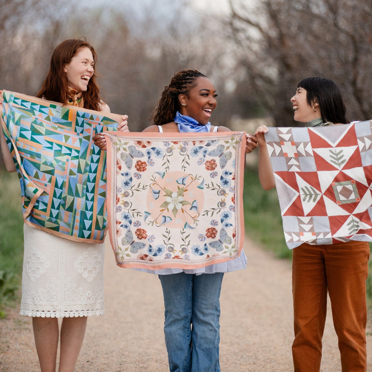 Prism, Columbine and Heirloom 100% silk scarves by Matty Miller, held open outdoors