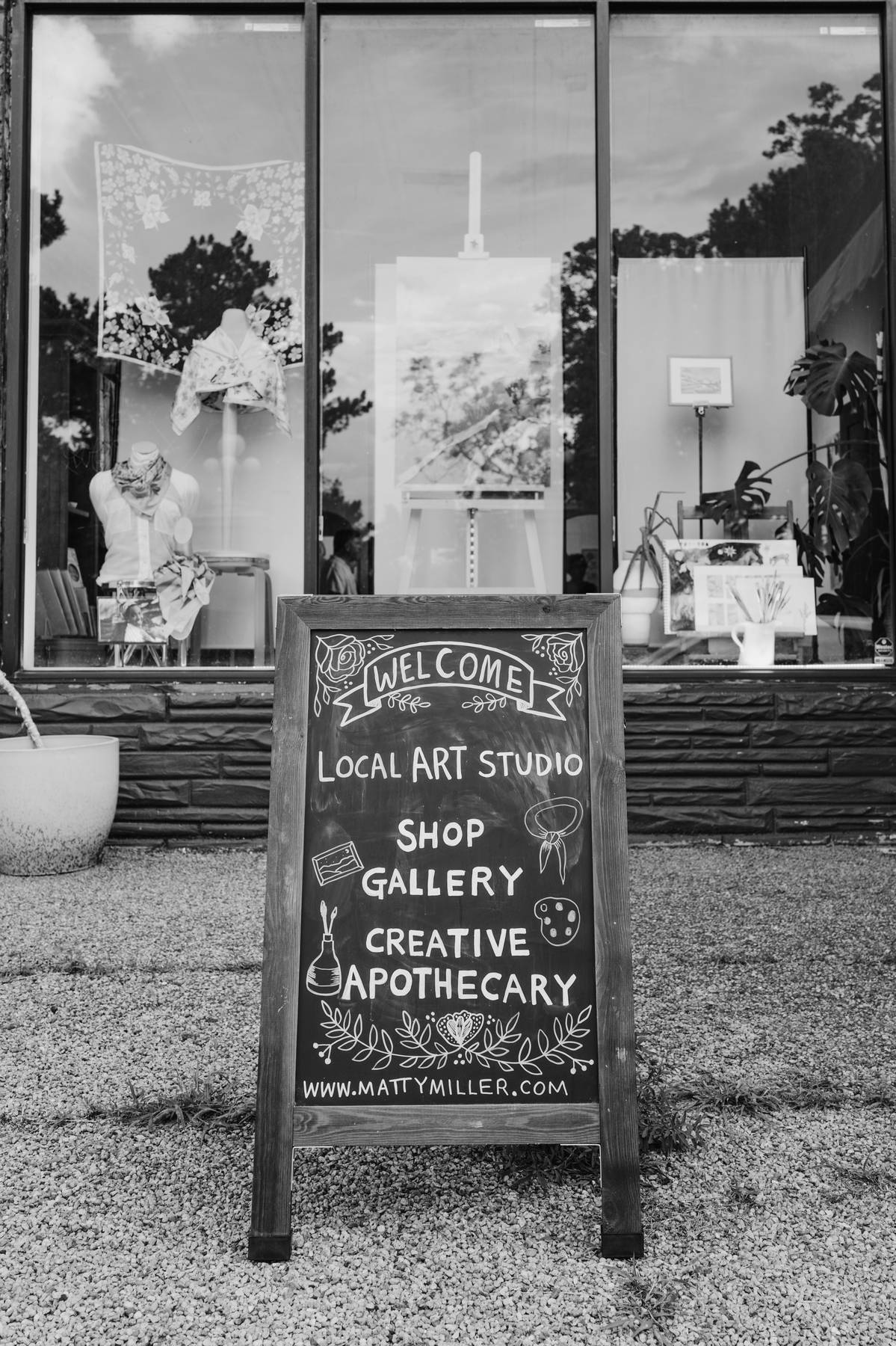 Black and white photo of the Matty Miller Studio storefront and sign near City Park in Denver